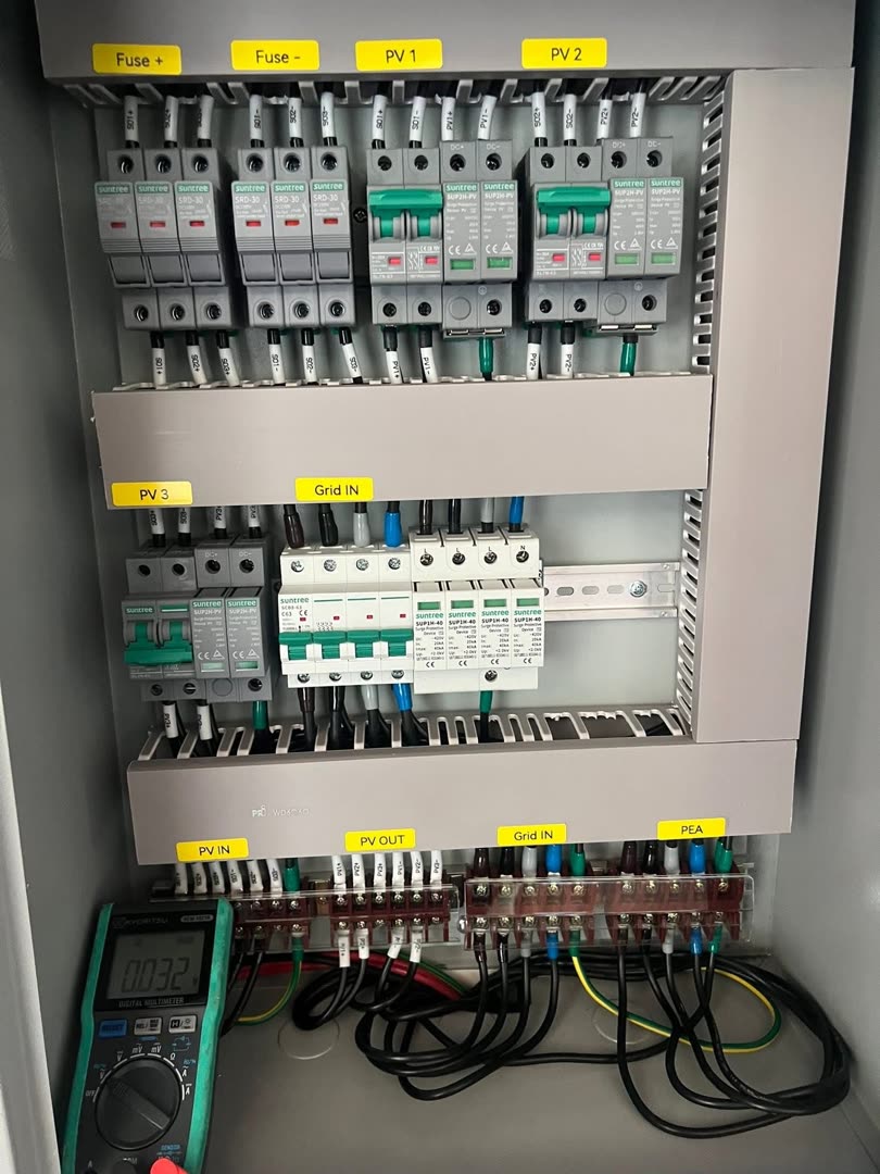 Suntree DC/AC combiner box with PV1-PV3 surge protection, voltage checked with a multimeter before energising — warehouse in Natai, Phang Nga